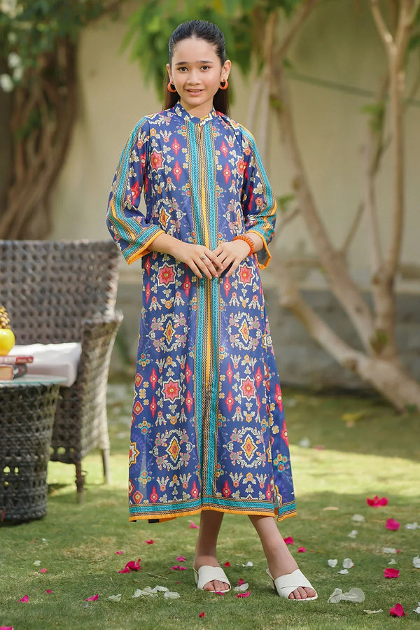 Girl wearing blue floral printed kurta with colorful trim, standing outdoors on grass with rose petals.