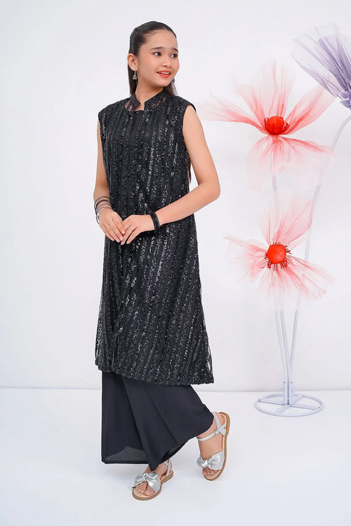 Girl wearing black sequin sleeveless kurta with palazzo pants, silver sandals, and floral decor