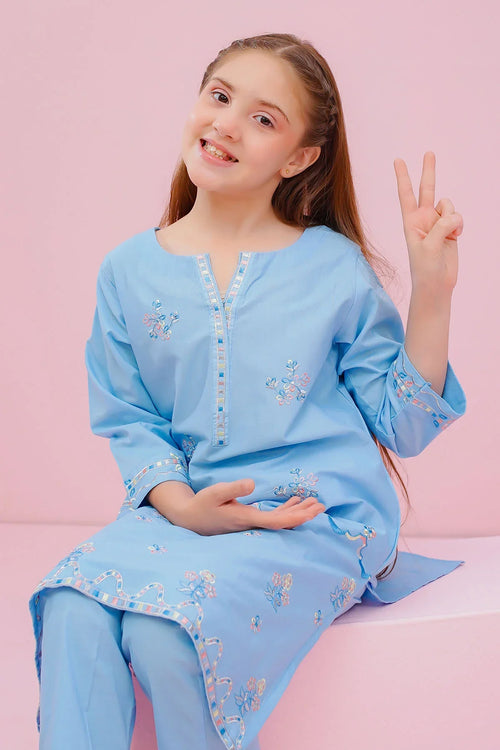 Girl in light blue embroidered kurta set, making peace sign against pink background