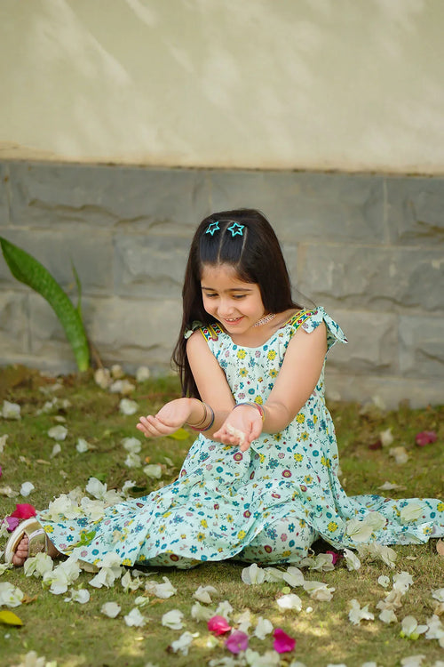 Little girl in floral dress playing with flower petals outdoors, trendy kids fashion