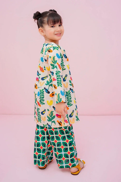 Girl in colorful bird-print top and green patterned pants, trendy kids fashion