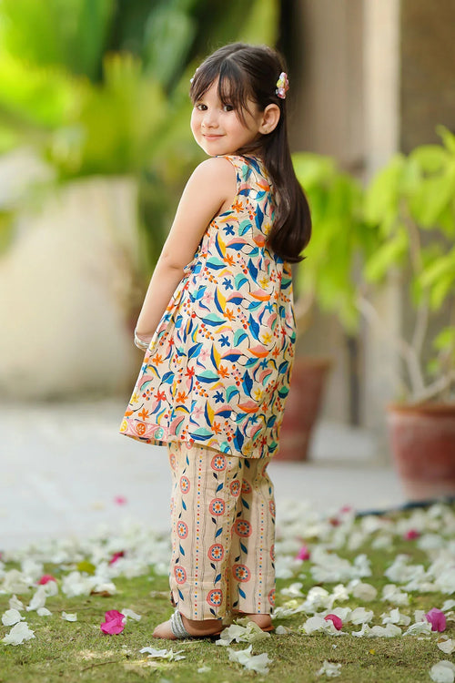 Little girl in colorful floral print kids outfit, standing on grass with flower petals, trendy summer wear