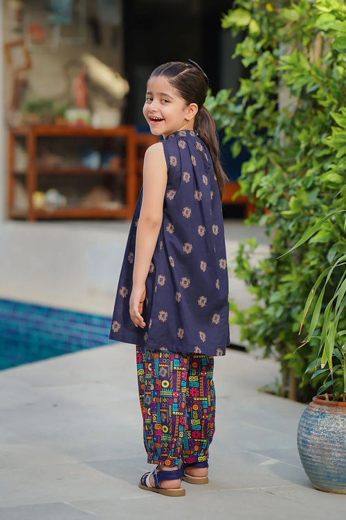 Girl in navy sleeveless top and colorful printed pants, smiling by poolside