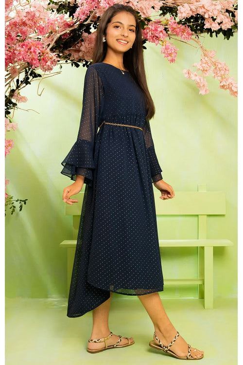Navy polka dot dress with flared sleeves and gold chain belt, styled with sandals against floral backdrop