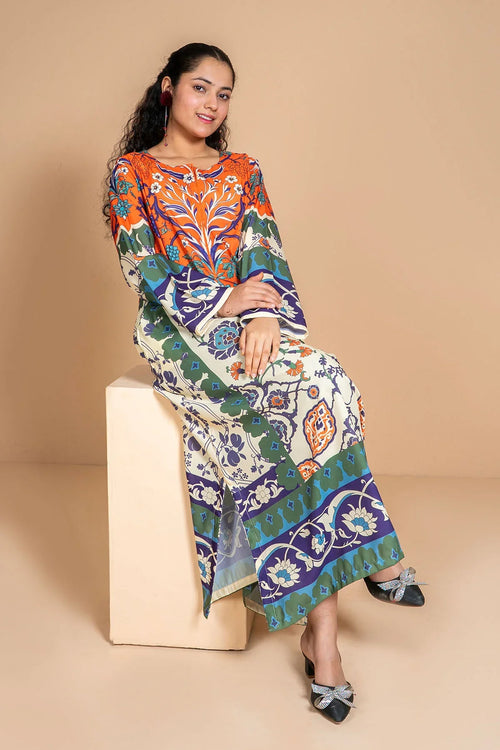 Woman in colorful floral print long dress with bell sleeves, sitting on block, stylish women's fashion