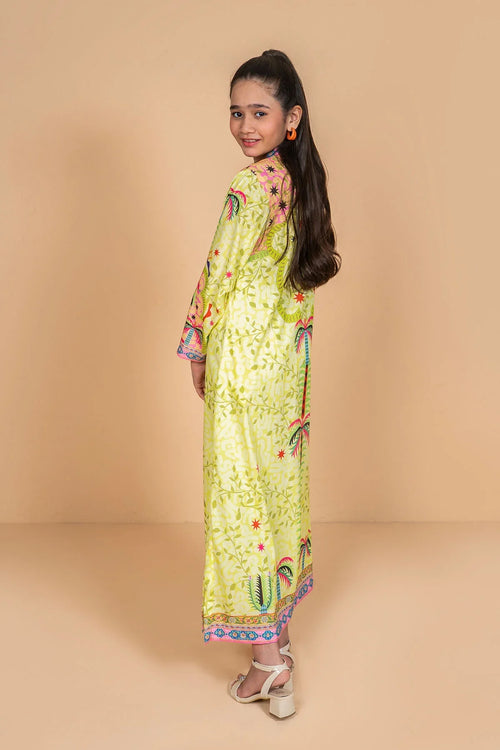 Girl wearing vibrant yellow printed kaftan dress with palm trees, perfect for kids' summer fashion.